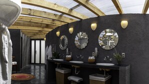 A modern bathroom with two sinks, large mirrors, and a ceiling with wooden beams. - Casa Maria Campiña (Jilotepec)