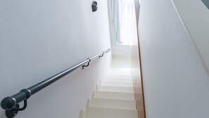 A staircase with a handrail, white walls, and a wooden floor. - Cilindar apartments (Zagreb)