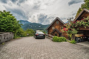 A car parked in front of a wooden house with a mountain view. - Beautiful wooden log house with a first-class view of the mountains! (Bad Goisern am Hallstättersee)