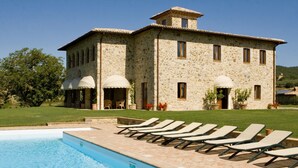 A stone building with a swimming pool and sun loungers. - Luxury Villa with private pool and Estate Winery in Umbria (Orvieto)