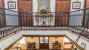 A spacious, multi-level interior with a grand staircase, wooden furniture, and a large ornate mirror. - Luxury Villa with private pool and Estate Winery in Umbria (Orvieto)