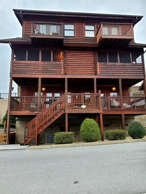 Un edificio de madera de varios pisos con balcones, una escalera y una base de piedra.