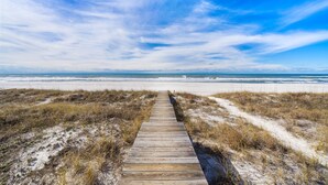 A wooden boardwalk leading to a beach with sand dunes and a clear blue sky. - "Soul Surfer" Dream Vacation Home w/ Direct Beach Access on the East End of Panama City Beach. Private Pool, Game Room, Large Suites + More! (Panama City Beach)
