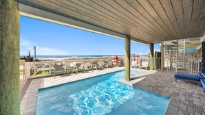 A pool area with a view of the beach, lounge chairs, and a covered deck. - "Soul Surfer" Dream Vacation Home w/ Direct Beach Access on the East End of Panama City Beach. Private Pool, Game Room, Large Suites + More! (Panama City Beach)