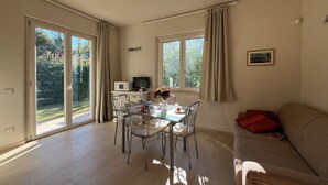 Un'ampia zona giorno con tavolo da pranzo, sedie, divano e televisione.