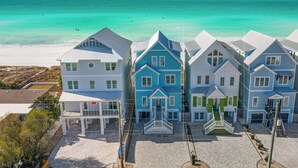 A beachfront property with multiple houses, a covered walkway, and a view of the ocean.