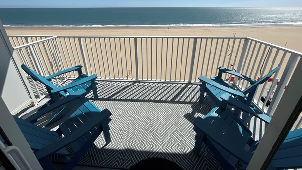 Ein Balkon mit Blick auf Strand und Meer.