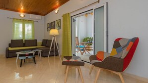 A modern living room with a sofa, coffee table, floor lamp, and colorful chairs.
