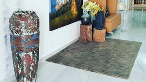 A modern living room with a large abstract painting, a decorative vase, and a sofa with cushions. - The Key Boutique Hotel (Lomé)
