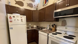 A compact kitchen with a refrigerator, dishwasher, stove, and microwave. - Horizon South 12C4: 1 BR / 1 BA condo in Panama City Beach, Sleeps 4 (Panama City Beach)