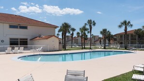A swimming pool with lounge chairs, palm trees, and a building with a red-tiled roof. - Horizon South 12C4: 1 BR / 1 BA condo in Panama City Beach, Sleeps 4 (Panama City Beach)