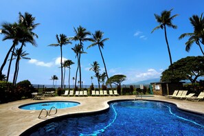 A swimming pool with lounge chairs and palm trees. - Fully Upgraded Kihei Condo Sweeping Ocean Views Private Lanai Pool Hot Tub (Kihei)