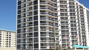 A multi-story hotel with a modern design, featuring balconies and large windows.