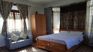A bedroom with a wooden bed, a sofa, and a wardrobe.