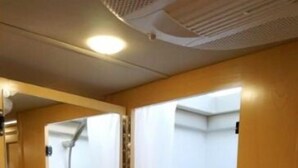 Une petite salle de bain avec une douche, un miroir et une porte.