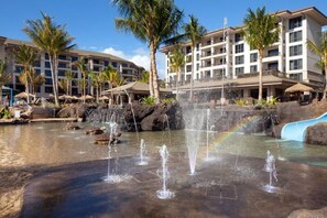 Relax by the resort's large pool, surrounded by palm trees and a soothing waterfall.