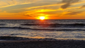 A sunset over the ocean with waves approaching the shore. - Pied-`a-Terre • Steps To Beach • Mangrove / Gulf View • Just Renovated (Naples)