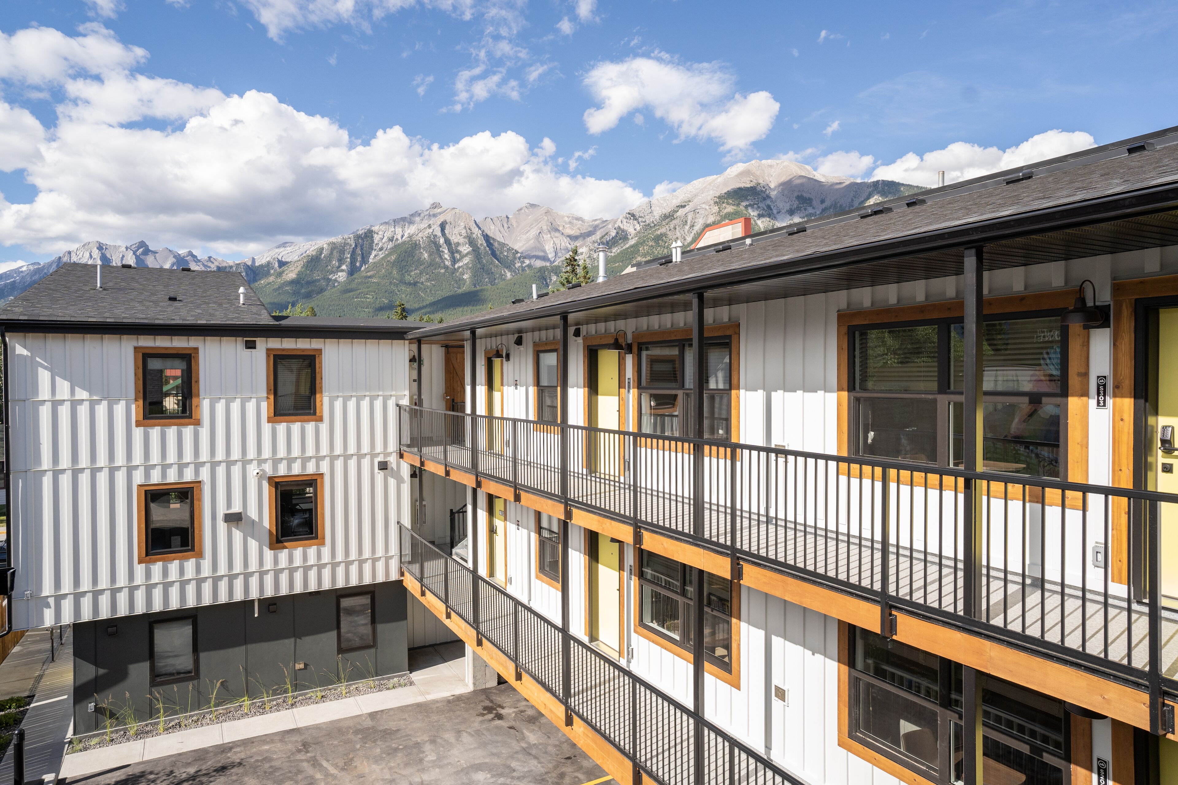 A multi-story building with balconies, a courtyard, and a mountain backdrop.