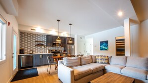 A modern apartment with a kitchen, dining area, and living room. - Basecamp Resorts Revelstoke (Revelstoke)