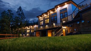 A modern multi-story building with a wooden facade, multiple windows, and a staircase leading to an upper level. - Basecamp Resorts Revelstoke (Revelstoke)