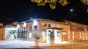 A building with multiple windows and a well-lit entrance. - Pousada Porto Da Barra (Porto Seguro)
