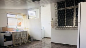 Eine kleine Küche mit Gasherd, Spüle und Kühlschrank.