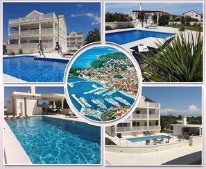 Un hotel de varios pisos con área de piscina, vistas a un pueblo costero y un puerto deportivo.