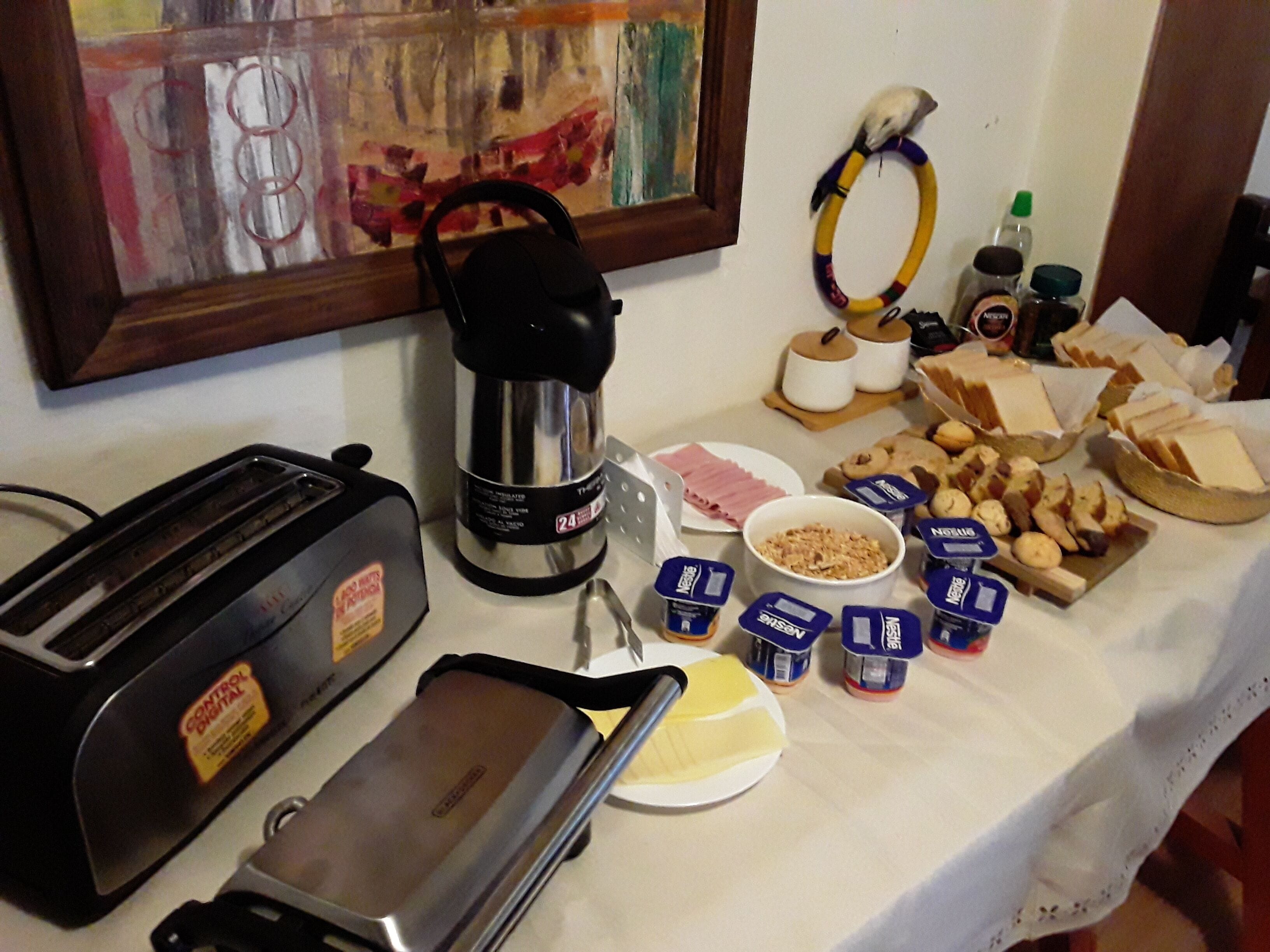 A breakfast buffet with various food items, a coffee maker, and a toaster.