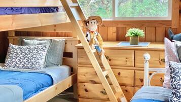Cozy bedroom with a bunk bed, single bed, and wooden dresser, perfect for relaxation and rest.