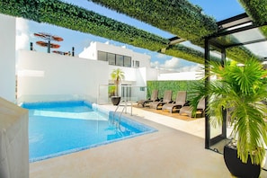 Relax by the clear pool surrounded by a deck and lounge chairs.