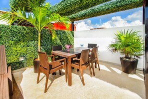 Enjoy al fresco dining on the patio surrounded by lush greenery.