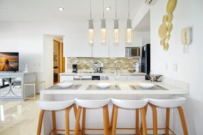 Enjoy casual dining at the central island with bar stools, equipped with a microwave and coffee machine.