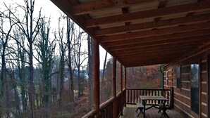 A wooden deck with a bench, overlooking a forested area. - Elk Cabin - 2 Bedroom/1 Bath Vacation Rental (Franklin)