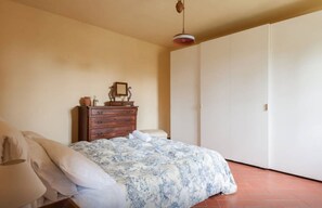 A bedroom with a bed, a dresser, a nightstand, and a wardrobe.