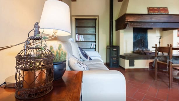Une pièce chaleureuse avec une table en bois, une lampe, une bibliothèque et une cheminée.