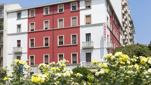 Un immeuble à plusieurs étages, doté d’une façade rouge et blanche, de balcons et d’une enseigne sur laquelle on peut lire « LONDRA ».
