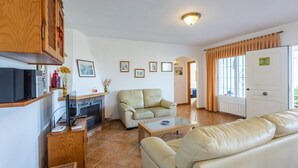 A living room with a fireplace, sofa, coffee table, and a door with a number sign.