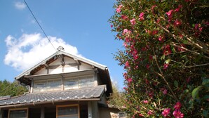 Una casa tradicional japonesa con tejado de tejas y un garaje.