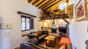 Ein gemütliches Wohnzimmer mit Kamin, Ledersofa und Holzmöbeln.