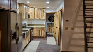 Eine Küche mit Holzschränken, Edelstahlgeräten und einer Arbeitsplatte aus Granit.