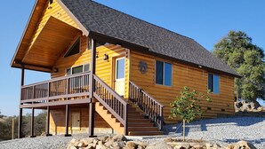Eine Blockhütte mit einem Balkon und einer Treppe zum Eingang.
