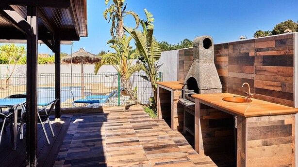 An outdoor patio with a pool, a barbecue area, and a wooden deck. - Chalet El Cancelín Conil de la Frontera by Ruralidays (Cádiz)
