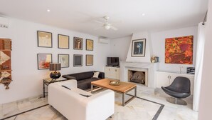 A modern living room with a white sofa, a wooden coffee table, and a fireplace. - Villa con Encanto Conil de la Frontera by Ruralidays (Cádiz)