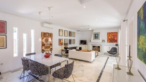 A spacious living area with a dining table, sofa, and fireplace. - Villa con Encanto Conil de la Frontera by Ruralidays (Cádiz)