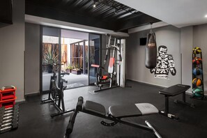 A gym with exercise equipment, a punching bag, and a bench. - Hotel MX lagunilla CDMX, Trademark Collection by Wyndham (Mexico City)