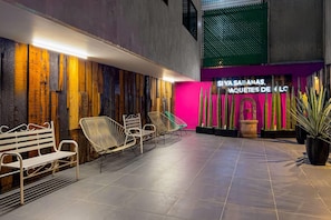 Un interior modern amb una zona de recepció, panells de paret de fusta i seients.