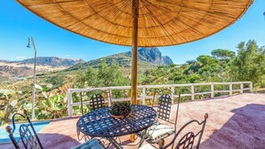 An outdoor patio with a table and chairs, a pool, and a view of a mountainous landscape. - Jara de El Gastor by Ruralidays (Cádiz)
