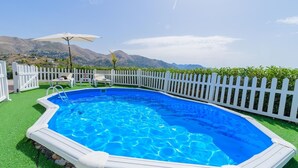 A rectangular swimming pool with a white fence and a white picket fence in the background.