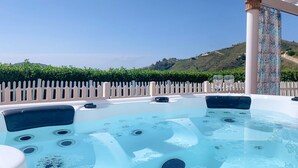 Una vasca idromassaggio con vista panoramica su un paesaggio collinare.