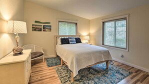 A bedroom with a bed, bedside lamps, a chair, a desk, and two windows. - Cute Cottage w/ Deck Walk 115 Ft to Brewery & Cafe (Poulsbo)